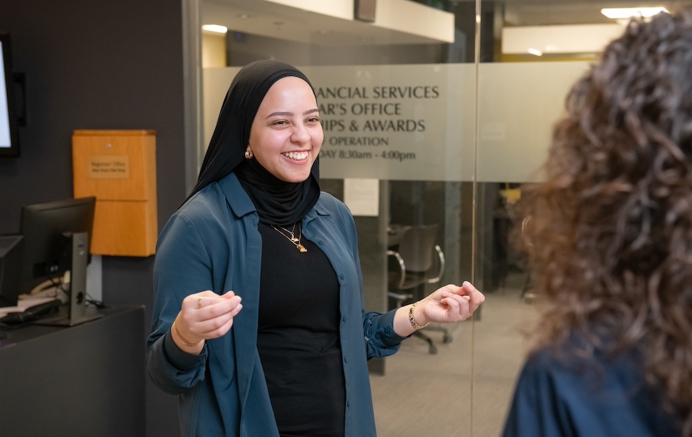 ͯŮ staff member Fairouz talking with a co-worker