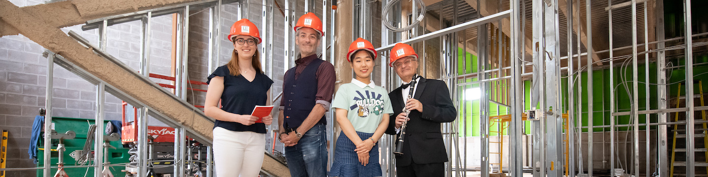 two faculty and two students in the new ͯŮ performance hall during its construction
